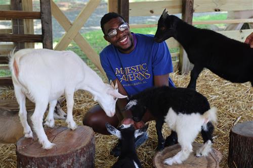 Tierece Wilson learns work can be fun as he "kids" around with the goats